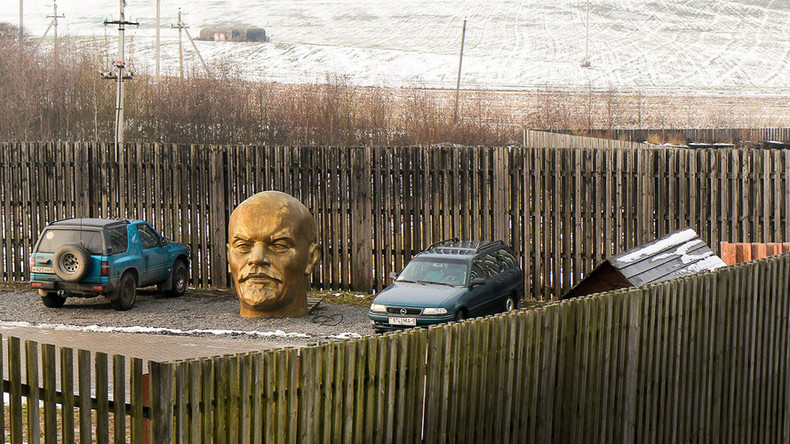 Photo of Bronze Lenin head in parking lot.